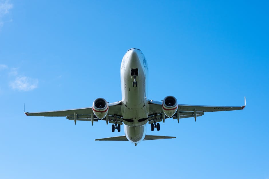 A low-angle shot of a Boeing airplane taking off, set against a clear, vivid blue sky.
