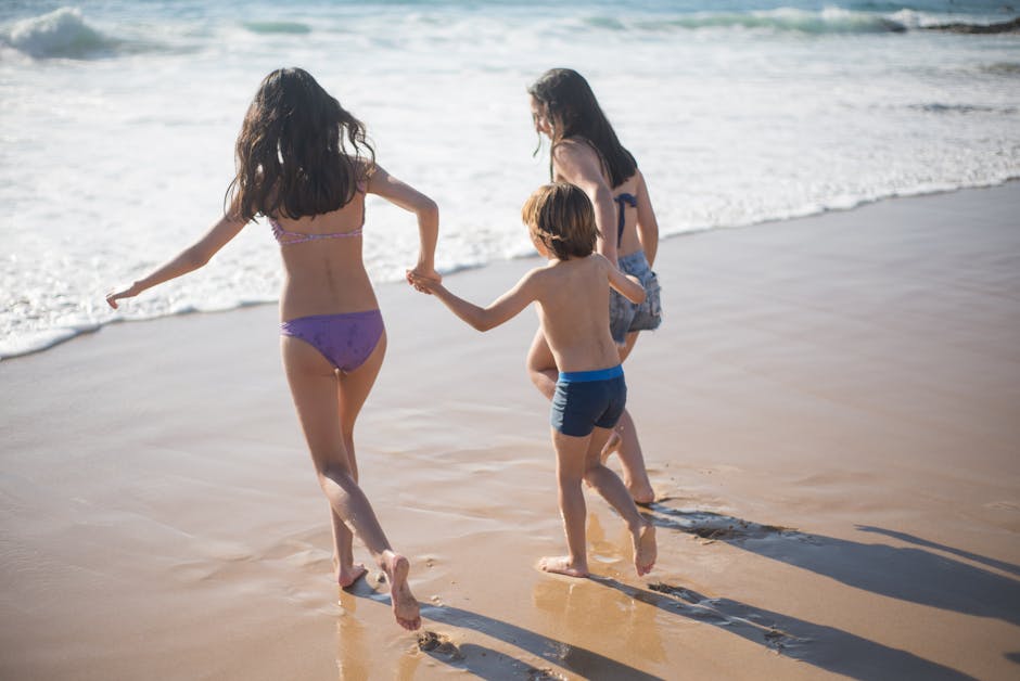 Three children play joyfully on a sunlit beach in Portugal, capturing the essence of summer and carefree fun.