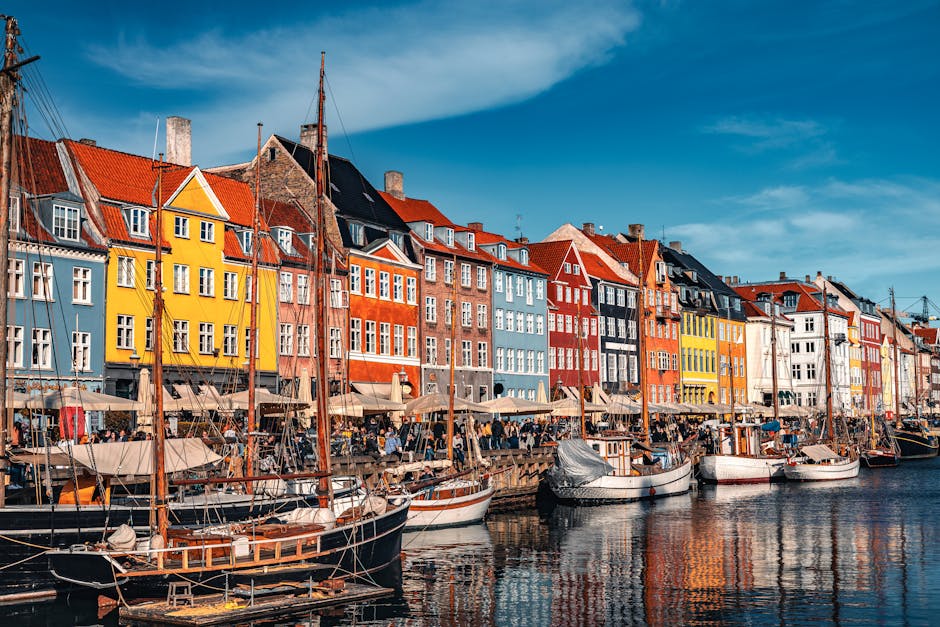 Vibrant view of Nyhavn with boats and colorful buildings in Copenhagen, Denmark.