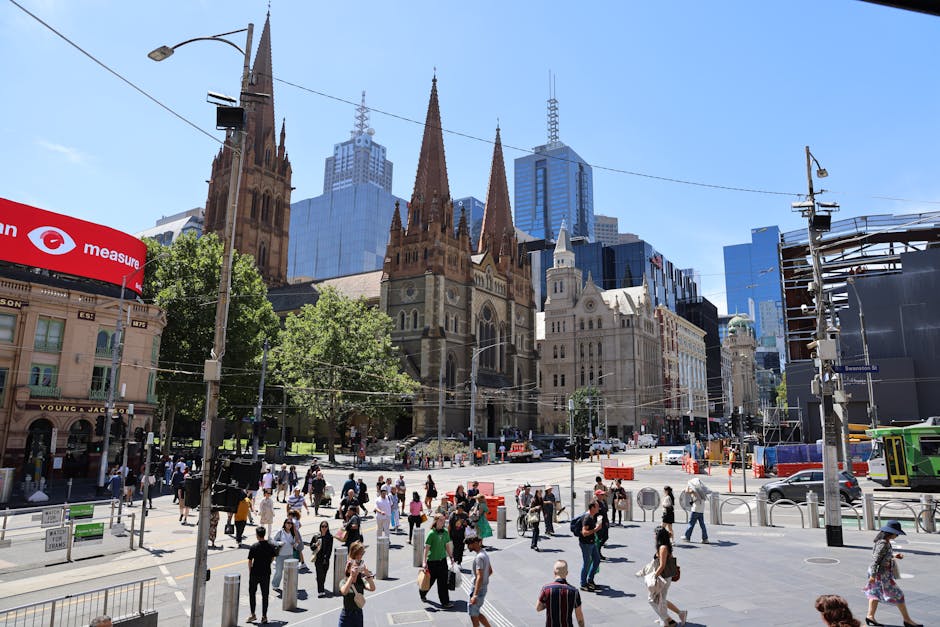 Dynamic scene of Melbourne's bustling street with St. Paul's Cathedral and modern skyline.