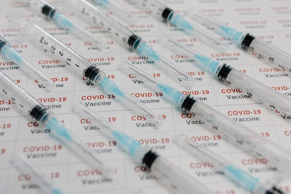 Close-up image of syringes on a COVID-19 vaccine background, representing medical research and vaccination efforts.